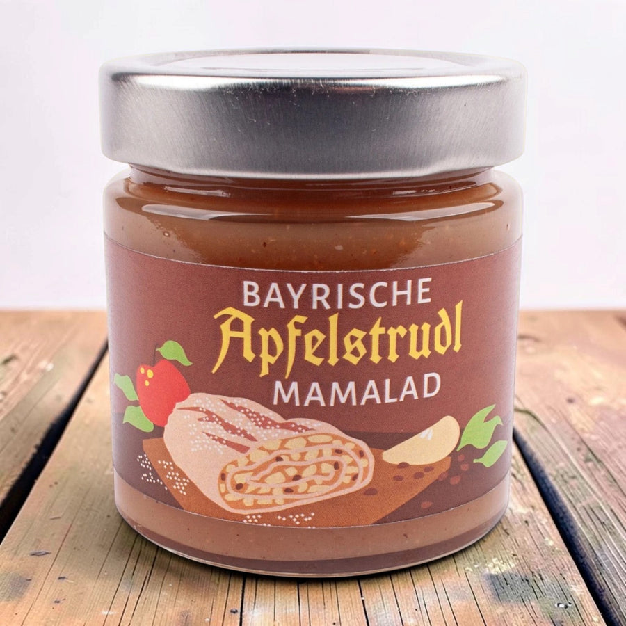 Glas Bayrische Apfelstrudl Mamalad, Fruchtaufstrich mit Apfel, Zimt und Rum-Rosinen, braunes Etikett mit Apfelstrudel, auf einem Holztisch.