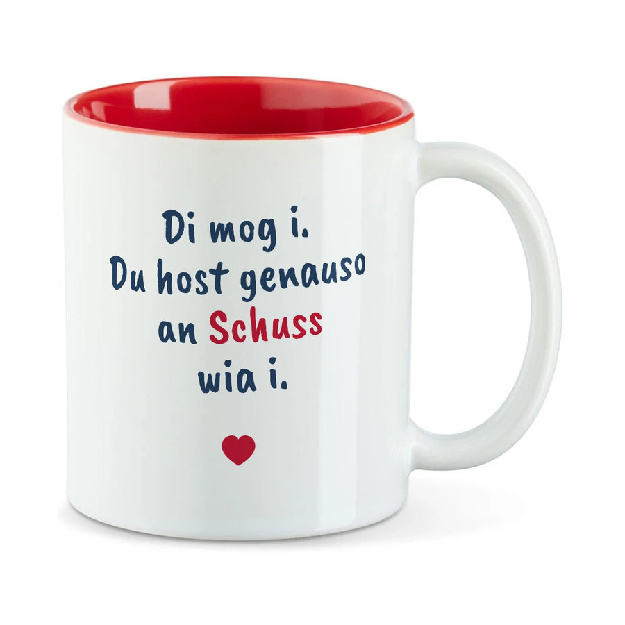 Weiße Tasse mit roter Innenseite und dem bairischen Spruch „Di mog i. Du host genauso an Schuss wia i.“ in Pinselschrift.