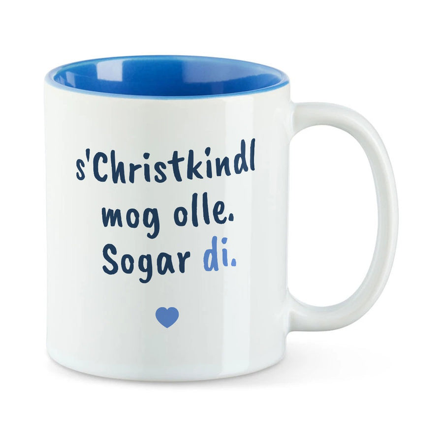 Weiße Tasse mit blauer Innenseite und dem bairischen Spruch „s'Christkindl mog olle. Sogar di.“ in Pinselschrift.