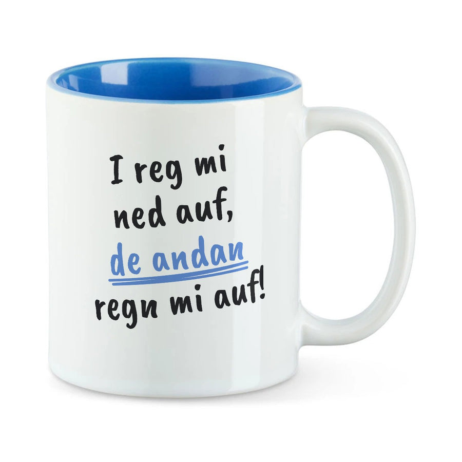 Weiße Tasse mit blauer Innenseite und dem bairischen Spruch „I reg mi ned auf, de andan regn mi auf!“ in Pinselschrift.