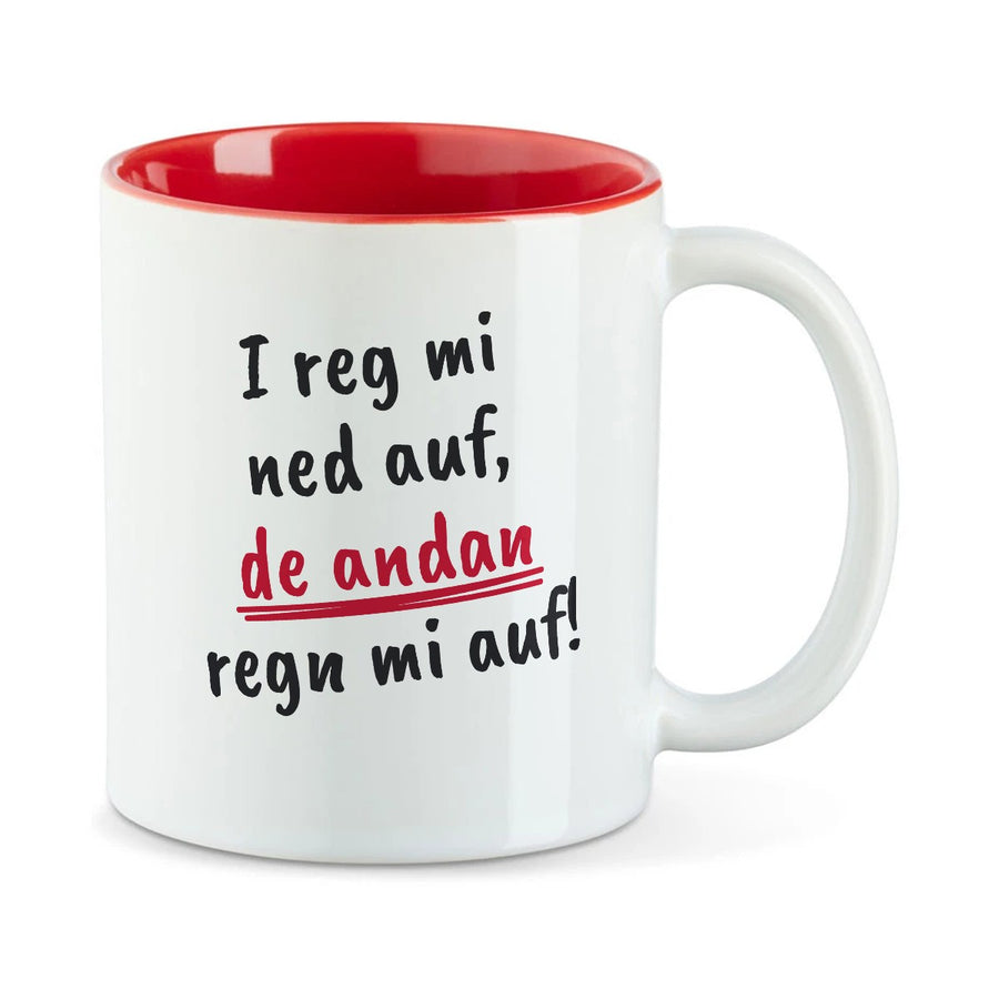 Weiße Tasse mit roter Innenseite und dem bairischen Spruch „I reg mi ned auf, de andan regn mi auf!“ in Pinselschrift.