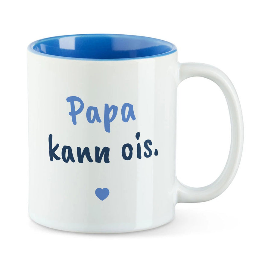 Weiße Tasse mit blauer Innenseite und dem bairischen Spruch „Papa kann ois.“ in Pinselschrift.