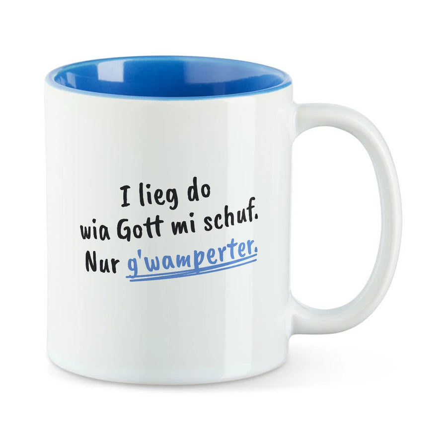 Weiße Tasse mit blauer Innenseite und dem bairischen Spruch „I lieg do wia Gott mi schuf. Nur g'wamperter.“ in Pinselschrift.