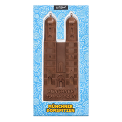 Verpackung der Münchner Domspitzen von Wildbach mit der Frauenkirche als Vollmilchschokolade-Relieftafel vor blauem Bayern-Muster