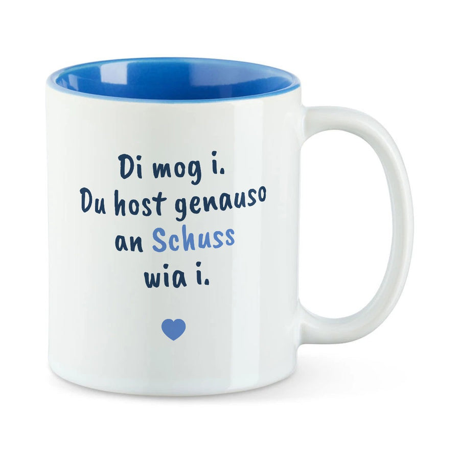 Weiße Tasse mit blauer Innenseite und dem bairischen Spruch „Di mog i. Du host genauso an Schuss wia i.“ in Pinselschrift.