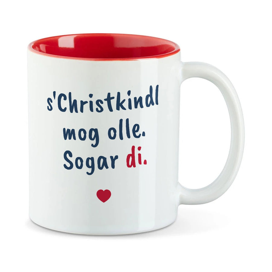 Weiße Tasse mit roter Innenseite und dem bairischen Spruch „s'Christkindl mog olle. Sogar di.“ in Pinselschrift.