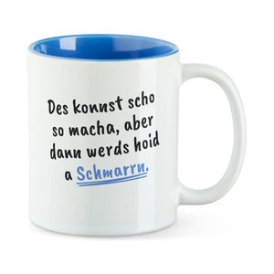 Weiße Tasse mit blauer Innenseite und dem bairischen Spruch „Des konnst scho so macha, aber dann werds hoid a Schmarrn.“ in Pinselschrift.