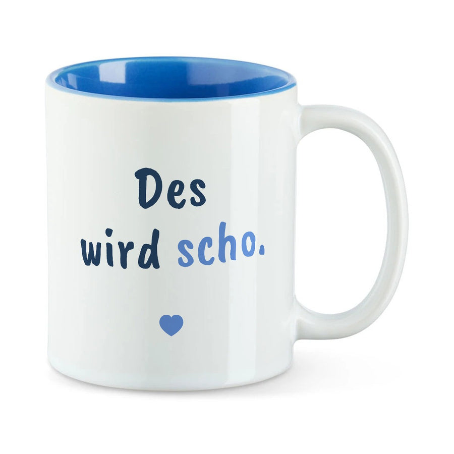 Weiße Tasse mit blauer Innenseite und dem bairischen Spruch „Des wird scho.“ in Pinselschrift.