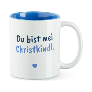 Weiße Tasse mit blauer Innenseite und dem bairischen Spruch „Du bist mei Christkindl.“ in Pinselschrift.