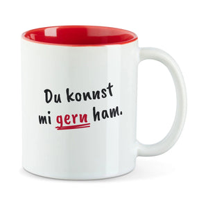 Weiße Tasse mit roter Innenseite und dem bairischen Spruch „Du konnst mi gern ham.“ in Pinselschrift.