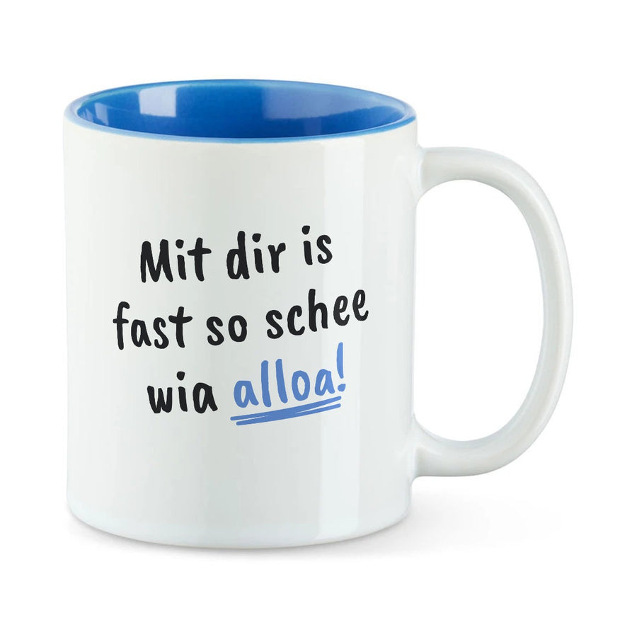 Weiße Tasse mit blauer Innenseite und dem bairischen Spruch „Mit dir is fast so schee wia alloa!“ in Pinselschrift.