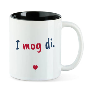 Weiße Tasse mit schwarzer Innenseite und dem bairischen Spruch „I mog di.“ in Pinselschrift.