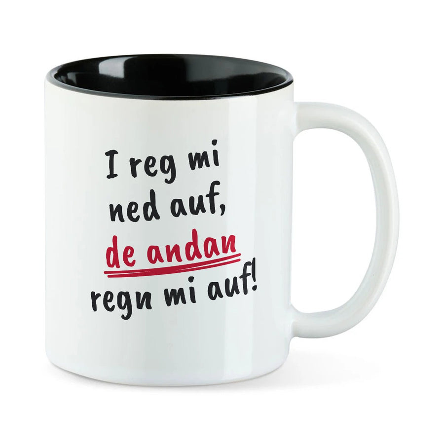 Weiße Tasse mit schwarzer Innenseite und dem bairischen Spruch „I reg mi ned auf, de andan regn mi auf!“ in Pinselschrift.