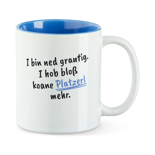 Weiße Tasse mit blauer Innenseite und dem bairischen Spruch „I bin ned grantig. I hob bloß koane Platzerl mehr.“ in Pinselschrift.