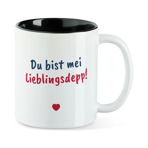 Weiße Tasse mit schwarzer Innenseite und dem bairischen Spruch „Du bist mei Lieblingsdepp!“ in Pinselschrift.