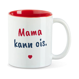 Weiße Tasse mit roter Innenseite und dem bairischen Spruch „Mama kann ois.“ in Pinselschrift.