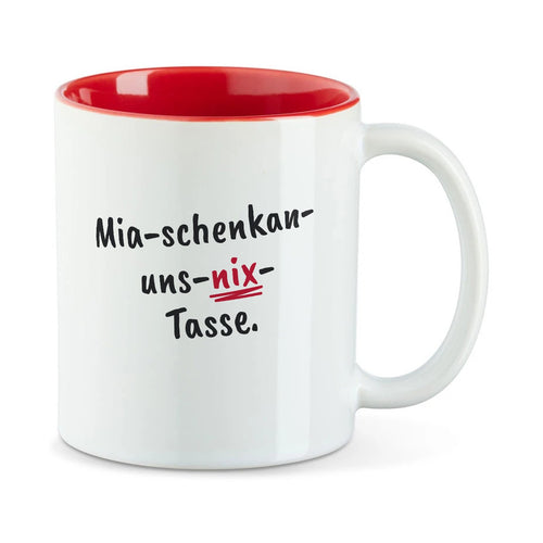 Weiße Tasse mit roter Innenseite und dem bairischen Spruch „Mia-schenkan-uns-nix-Tasse.“ in Pinselschrift.