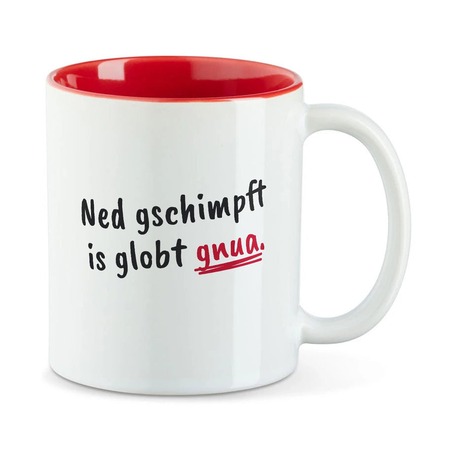 Weiße Tasse mit roter Innenseite und dem bairischen Spruch „Ned gschimpft is globt gnua.“ in Pinselschrift.