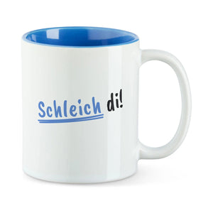 Weiße Tasse mit blauer Innenseite und dem bairischen Spruch „Schleich di!“ in Pinselschrift.