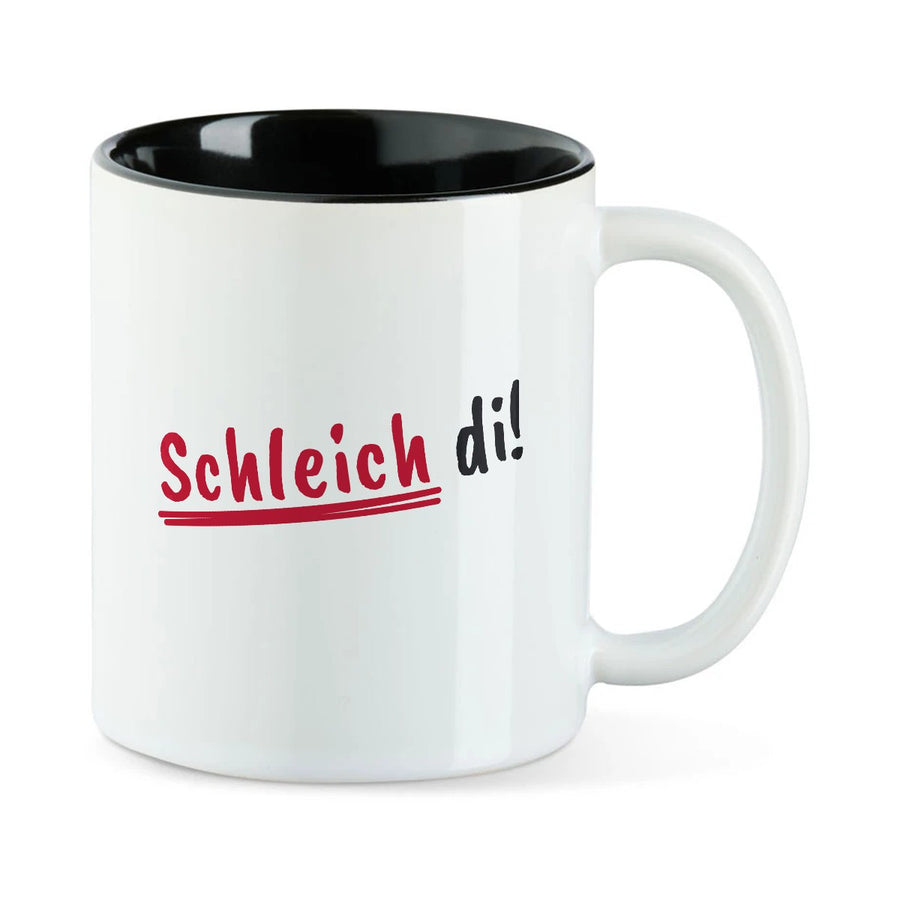 Weiße Tasse mit schwarzer Innenseite und dem bairischen Spruch „Schleich di!“ in Pinselschrift.